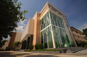 A modern building with large glass windows and a beige facade. - Srilamduan Hotel (Sisaket)