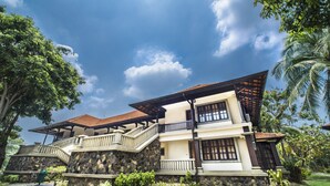 A two-story house with a stone facade, a balcony, and a tiled roof. - Sebana Cove Resort (Bandar Penawar)