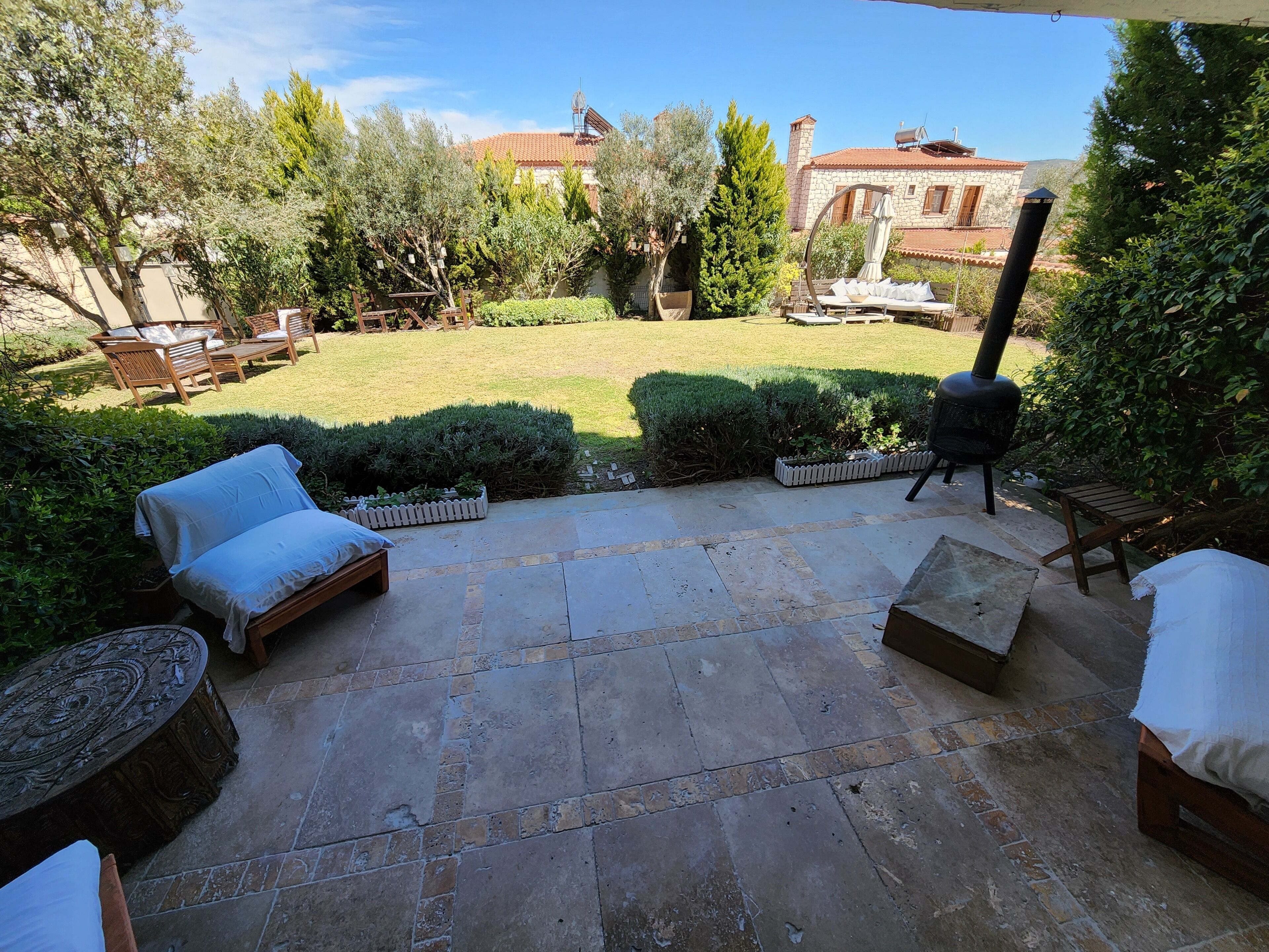 A patio with stone flooring, outdoor furniture, and a barbecue grill.