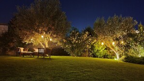 An outdoor seating area with wooden furniture and string lights. - Jakamar Alacati (Cesme)