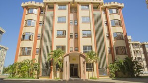 Un edificio de varios pisos con fachada simétrica, ventanas amplias y una entrada central.