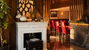 A lobby with a fireplace, red chairs, a reception desk, and a decorative wall. - Classes Hotel (Istanbul)