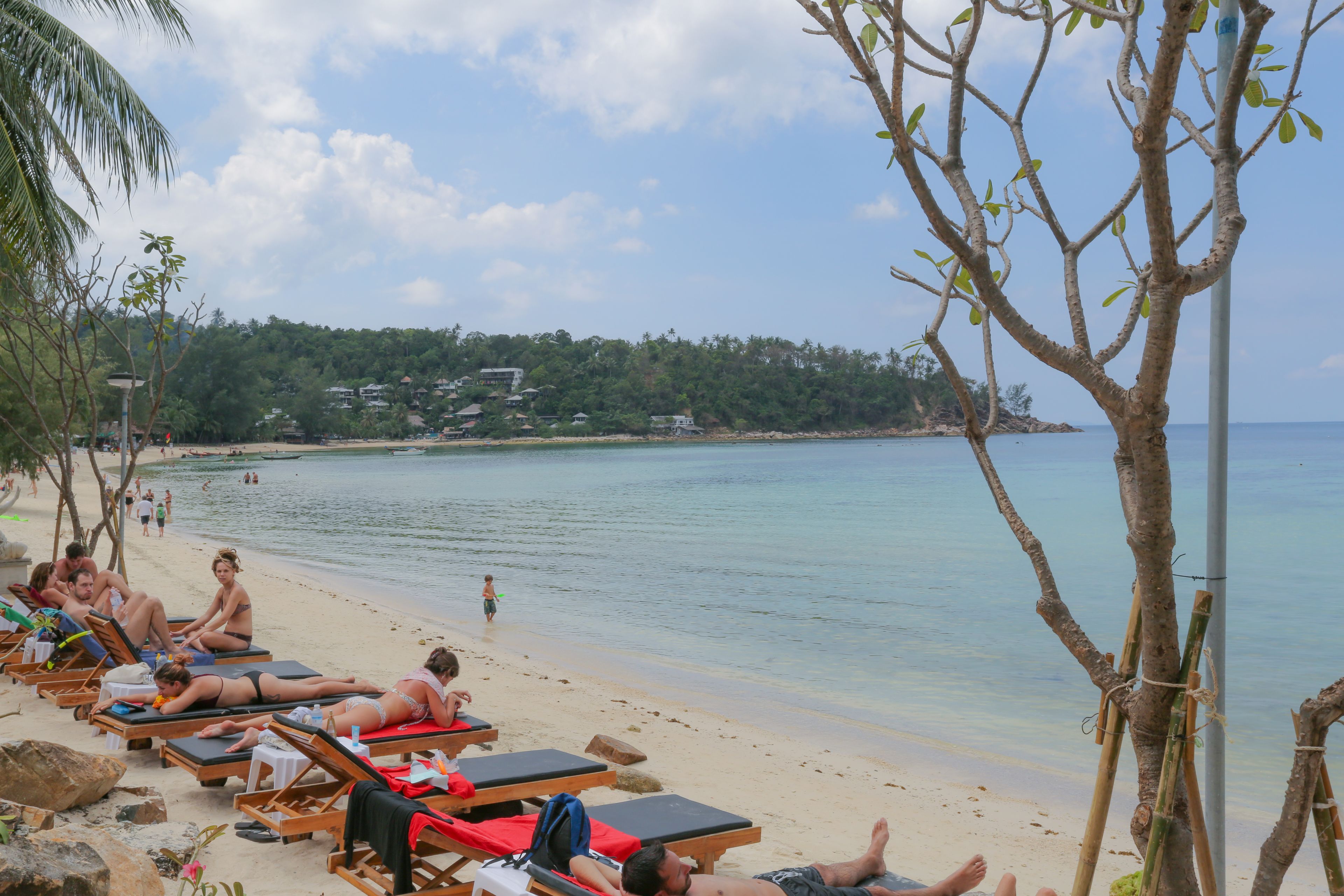 A beach with sun loungers and a view of the sea.