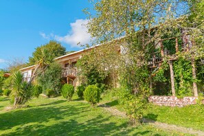 A two-story building with a balcony, surrounded by lush greenery and a clear sky. - Agva Masal Evi (Sile)