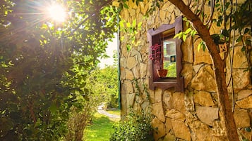 Un edificio de piedra con ventana y marco de madera.