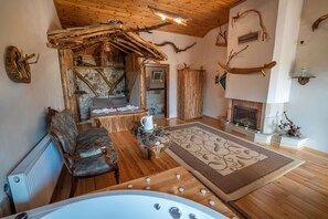 A rustic interior with a stone fireplace, wooden furniture, and a large window. - Agva Masal Evi (Sile)