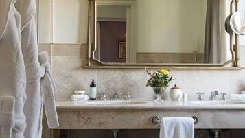 Un baño con tocador de mármol, un espejo grande y un perchero para toallas.