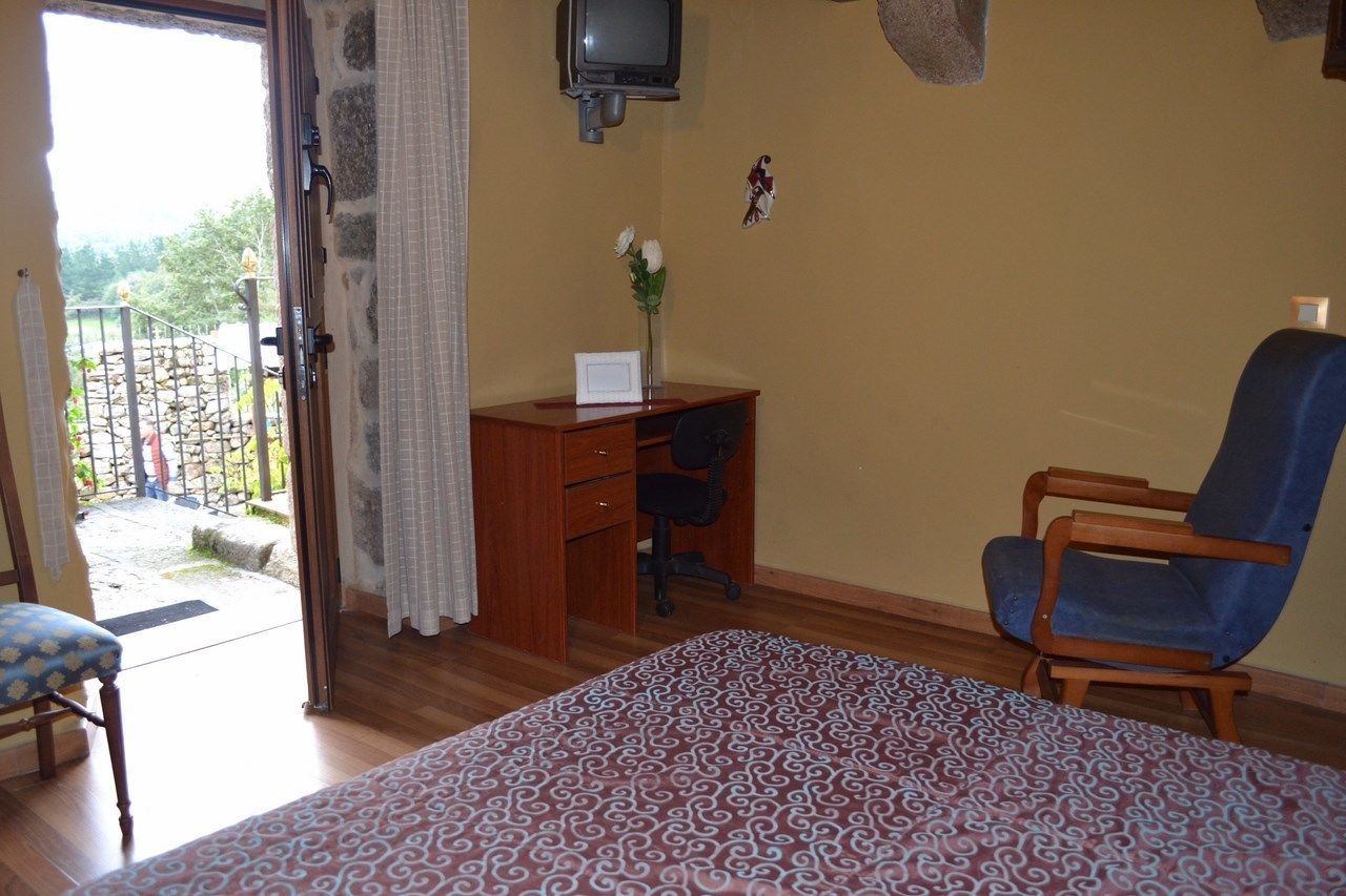 Een slaapkamer met een bed, een bureau, een stoel en een televisie.