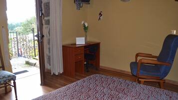 Een slaapkamer met een bed, een bureau, een stoel en een televisie.