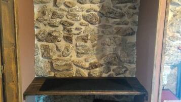 Un muro de piedra con un estante de madera y un marco de puerta de madera.
