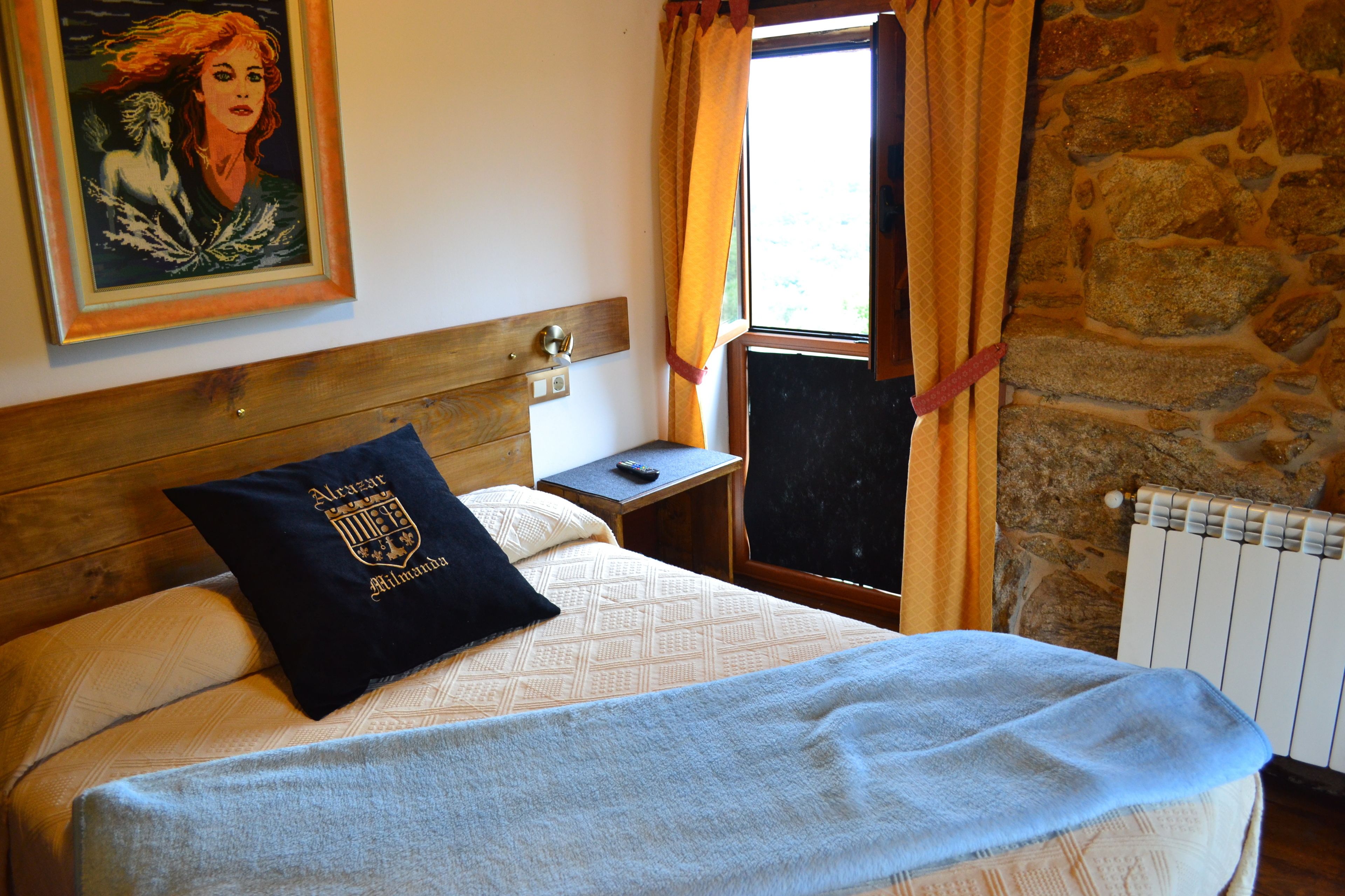 A bed with a headboard, a nightstand, a painting, and a window with curtains.