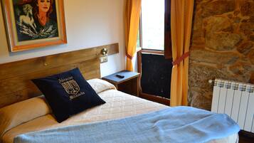 A bed with a headboard, a nightstand, a painting, and a window with curtains.
