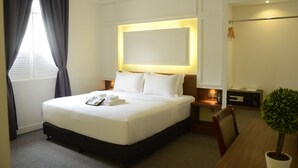 A hotel room with a large bed, bedside tables, a desk, and a potted plant. - TheBlanc Boutique Hotel (Malacca City)