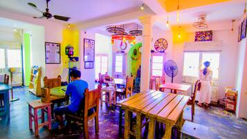 Enjoy dining in a vibrant space with eclectic decor, featuring a variety of seating arrangements and artwork.