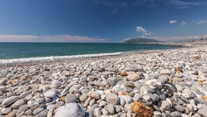 A pebble beach with a view of the sea and a distant mountain. - Taleocean (Hualien City)