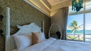 A bedroom with a bed, a hanging chair, and a view of the ocean. - Taleocean (Hualien City)
