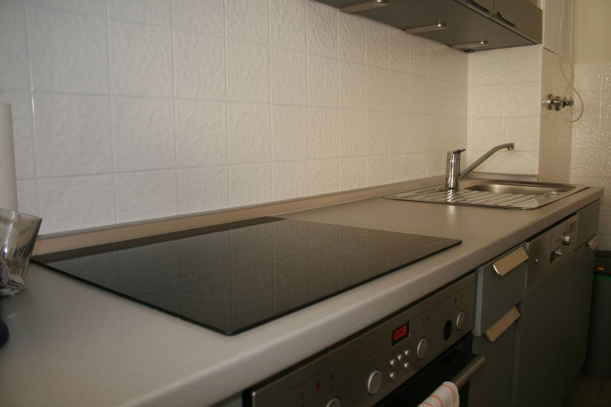 A kitchen with a built-in stove, a sink, and a microwave.