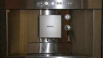 Eine Edelstahl-Espressomaschine mit Bedienfeld und Wasserbehälter.