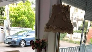 A room with wicker furniture, a table, and a vase of flowers. - Chanathinat Place (Udon Thani)