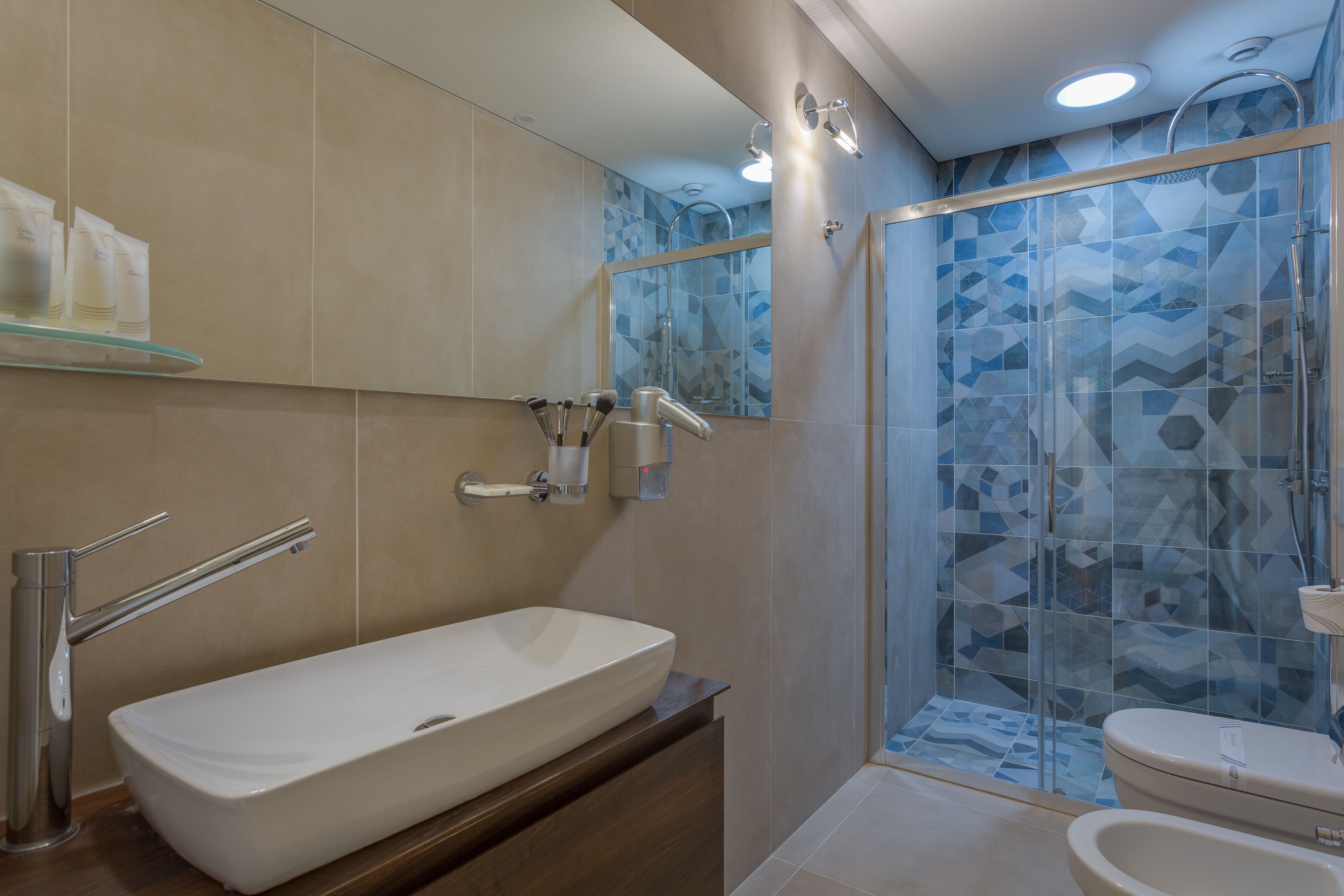 Une salle de bain moderne avec un grand lavabo blanc, une douche à parois de verre et des toilettes.