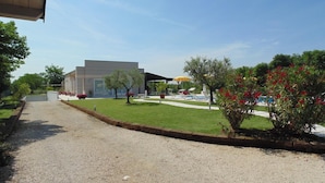 A modern building with a gravel driveway leading to a pool area. - Agriturismo Dell'orto (Verona)