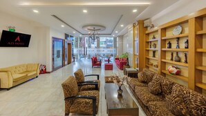 A hotel lobby with a reception desk, sofas, and a chandelier. - A25 Premium Hotel - 20 Bui Thi Xuan (Ho Chi Minh City)