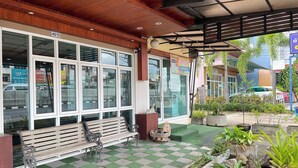 A building with large windows, a bench outside, and potted plants. - Bann Lhong Rak Krabi (Krabi)