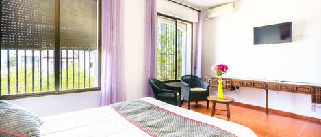 Ein Hotelzimmer mit Bett, Schreibtisch, Stuhl und Fernseher.