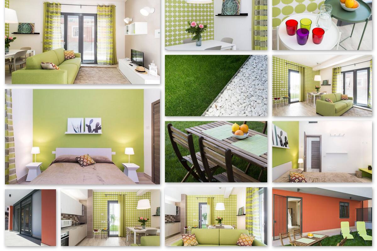 Una habitación de hotel con un sofá verde, una cama con cabecera marrón, una mesita con lámpara y una ventana con cortinas.