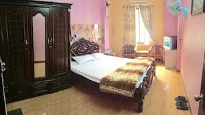 A bedroom with a bed, wardrobe, and a small table with a chair. - Kocmoc Ha Long (Ha Long)