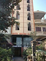 Un hotel con un letrero que dice 'HOTEL KOCMOCH HOTEL' y un balcón con barandillas.