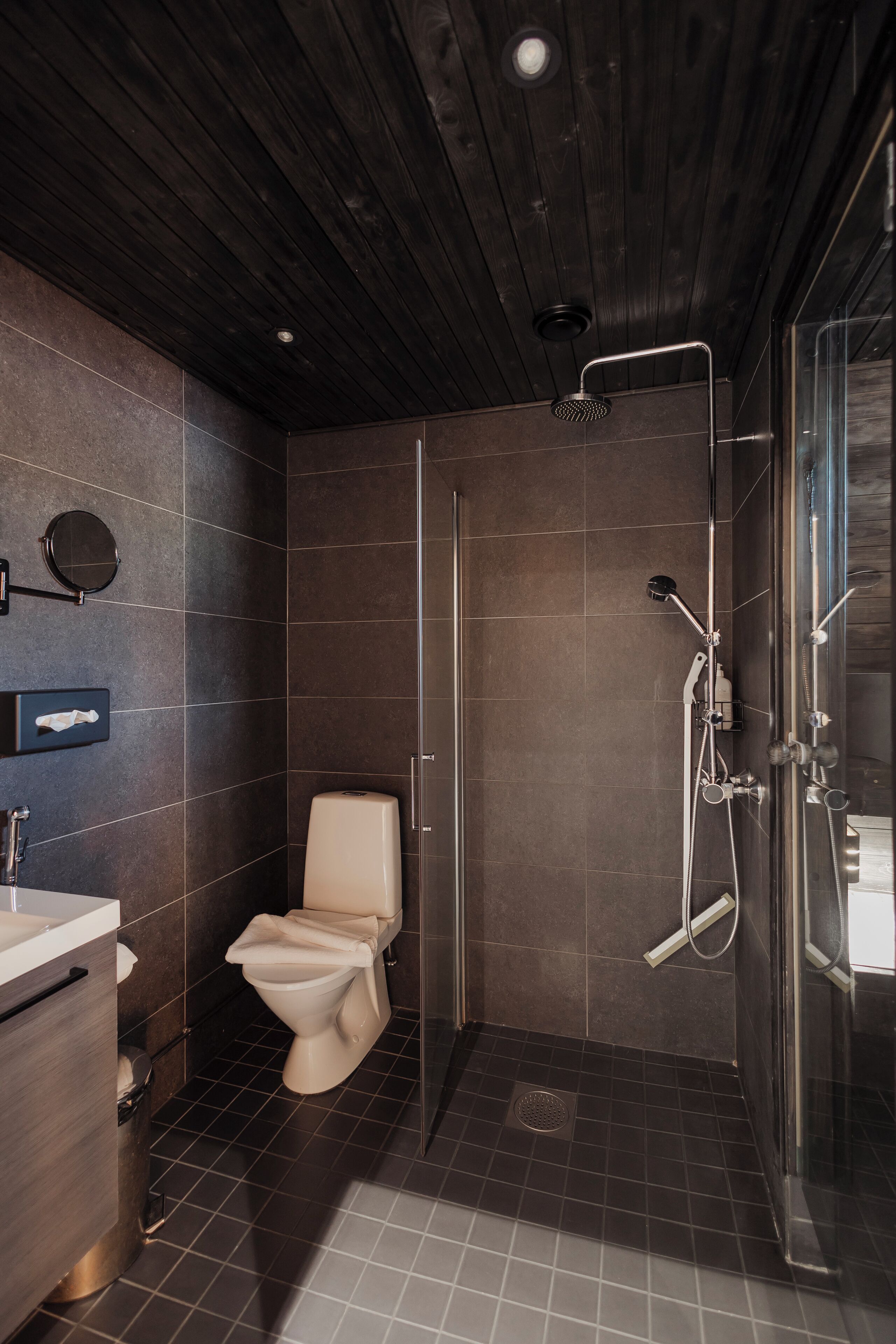 Ein modernes Badezimmer mit Toilette, Waschbecken und Duschbereich.
