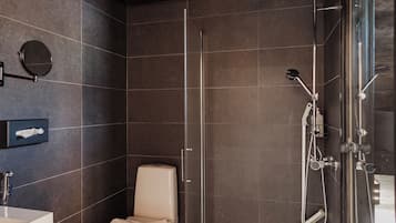 Ein modernes Badezimmer mit Toilette, Waschbecken und Duschbereich.