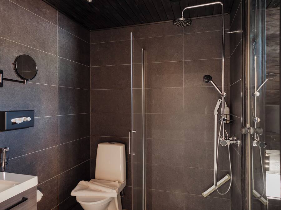 Ein modernes Badezimmer mit Toilette, Waschbecken und Duschbereich.