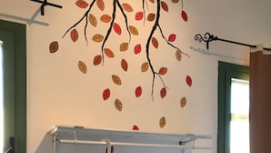A room with a wall-mounted drying rack holding a grey shirt and a folded blue garment. A shelf with a red object is below the rack. - Hostal Cling 43 (Deltebre)