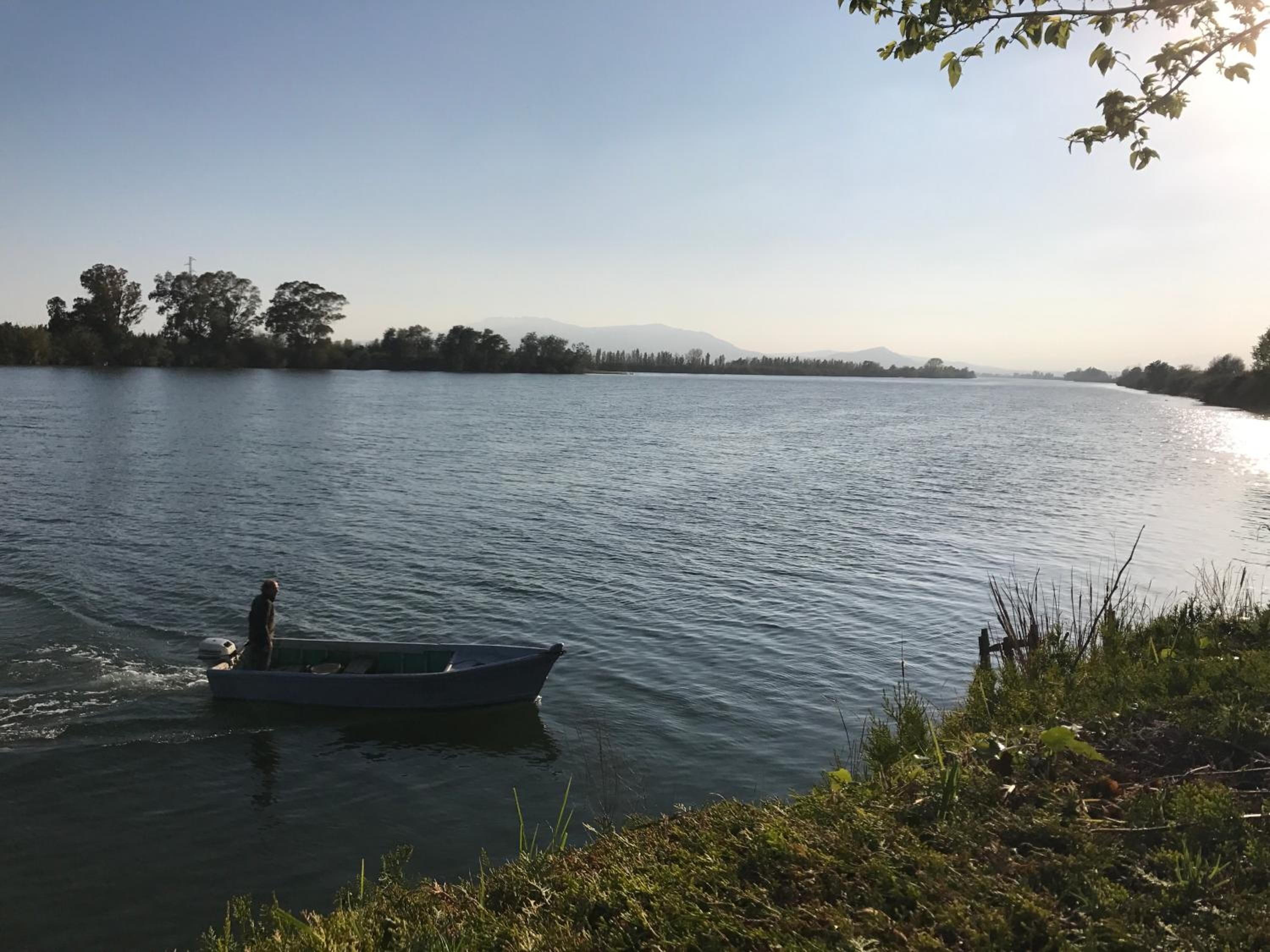 Un río tranquilo con un barco pequeño en el agua.