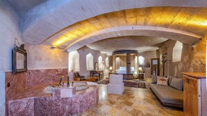 Un intérieur spacieux avec un comptoir d’accueil en marbre, un espace salon et une grande fenêtre laissant entrer la lumière naturelle.