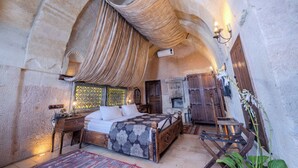 Une chambre à coucher avec un grand lit, une armoire en bois, une table de chevet et une fenêtre avec des rideaux.