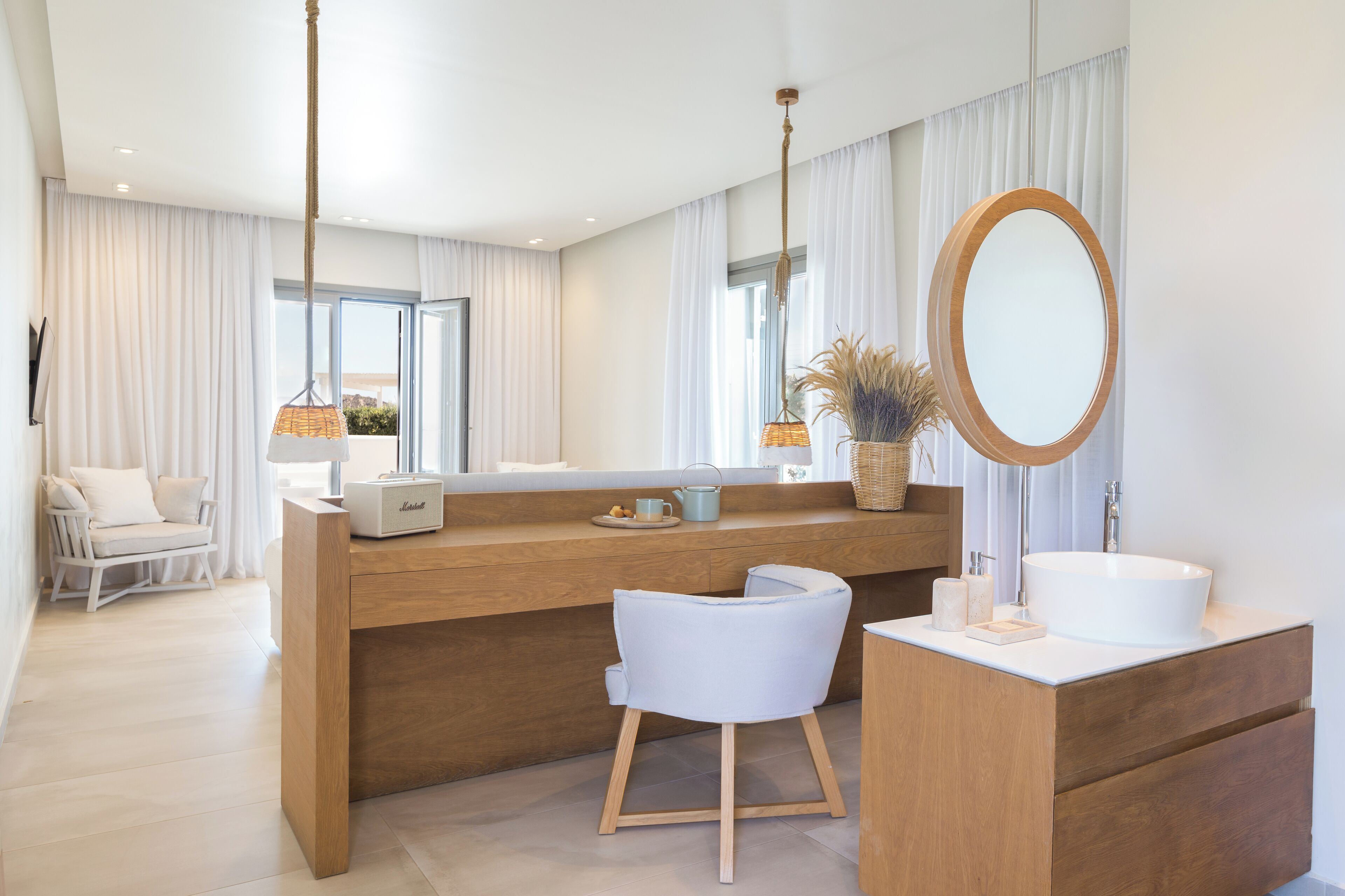 A modern bathroom with a wooden vanity, a large mirror, and a white sink.
