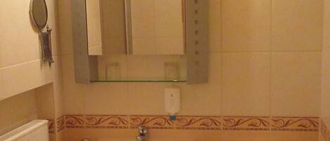 Un baño con lavamanos, espejo y retrete.