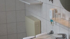 A bathroom with a toilet, sink, and mirror. - Neuenkirchener Hof (Neuenkirchen)