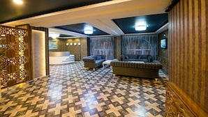 A hotel lobby with patterned flooring, seating areas, and a reception desk. - Kars-i Sirin Hotel (Kars)