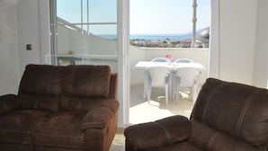 A balcony with two brown leather sofas, a white table, and chairs. - Akbük Palace Hotel & Residence (Didim)