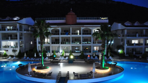 A hotel with a swimming pool, lounge chairs, and palm trees. - Akbük Palace Hotel & Residence (Didim)