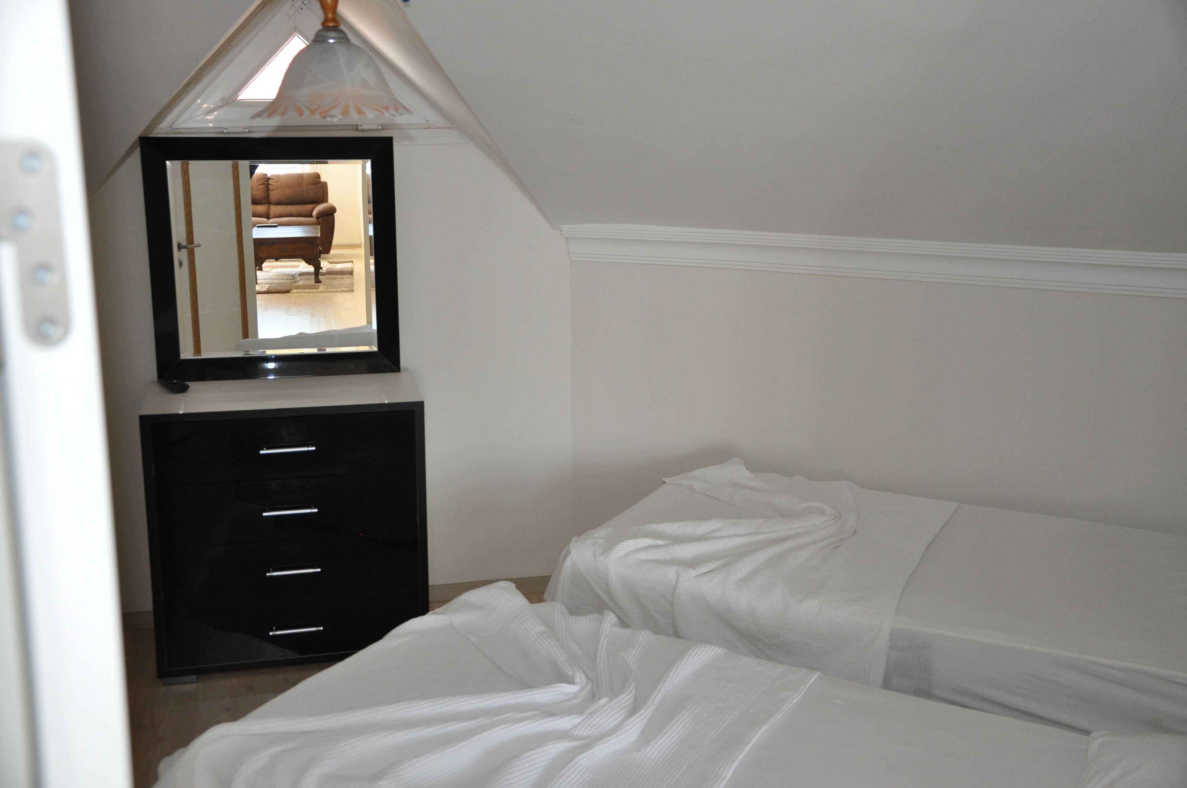 A bedroom with a bed, a dresser, and a mirror.
