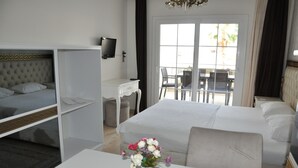 A hotel room with a bed, a desk, a chair, and a TV. - Akbük Palace Hotel & Residence (Didim)