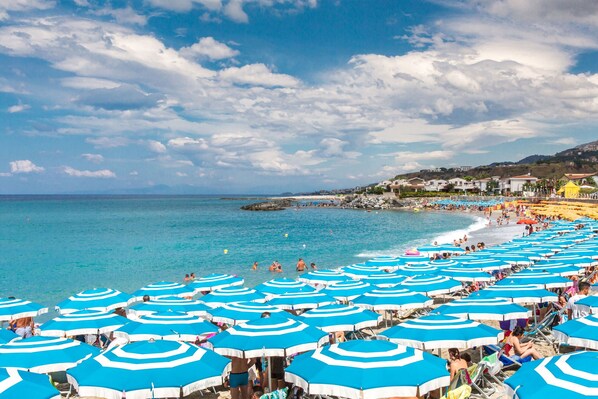 Chaise longue, parasol, serviettes de plage, volleyball