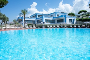Piscine extérieure en saison, parasols, chaises longues