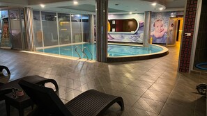 Zona de piscina con paredes de vidrio, sauna y spa.