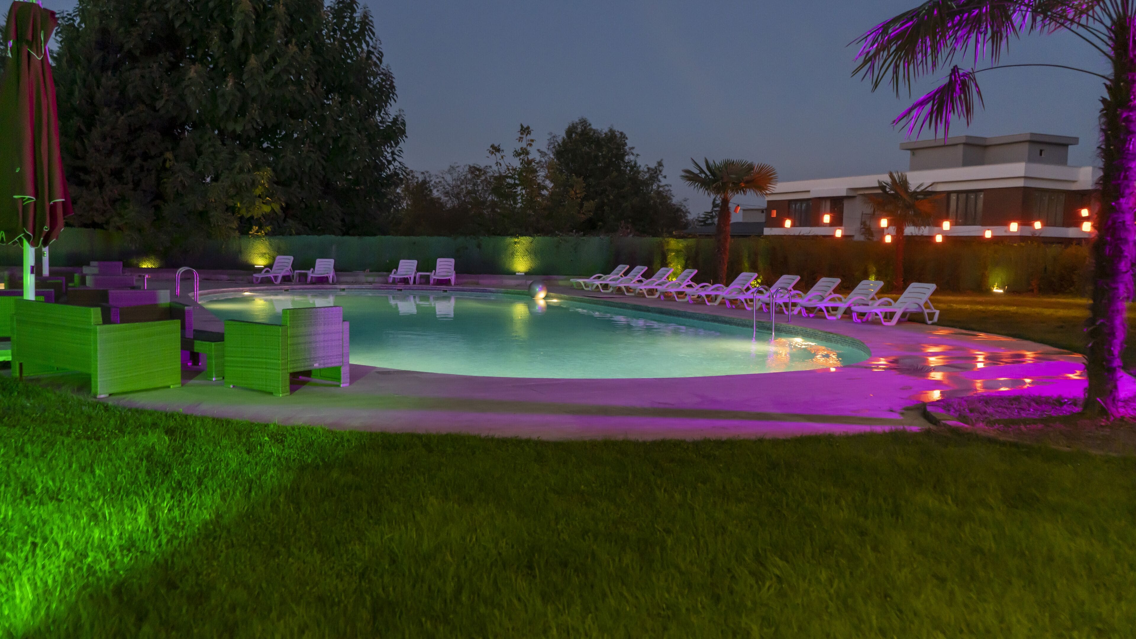 Una piscina techada, una piscina al aire libre, sombrillas